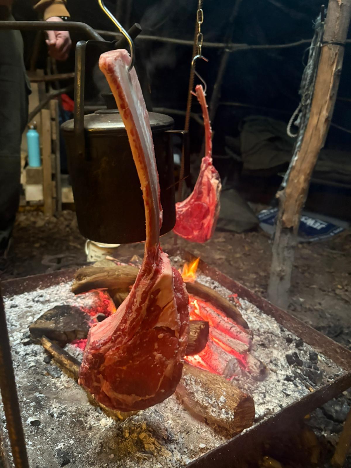 Meat hanging to cook over an open fire