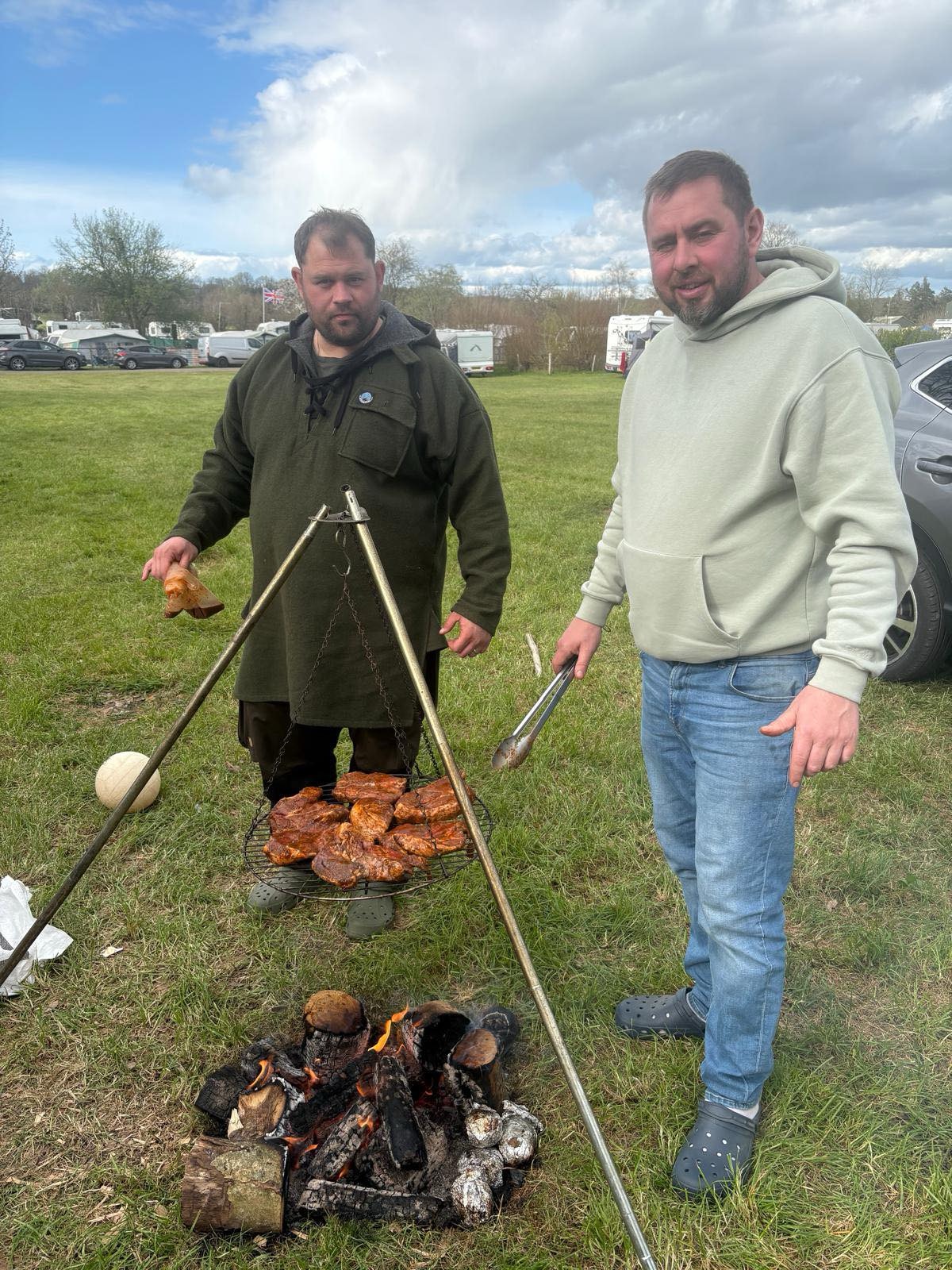Tony and James cooking over an open fire at an outdoor event